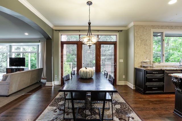 dining space with ornamental molding, an inviting chandelier, and dark hardwood / wood-style flooring