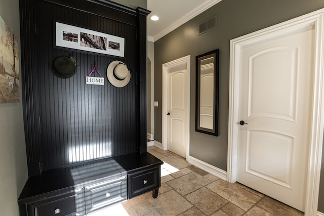 mudroom featuring crown molding and a barn door