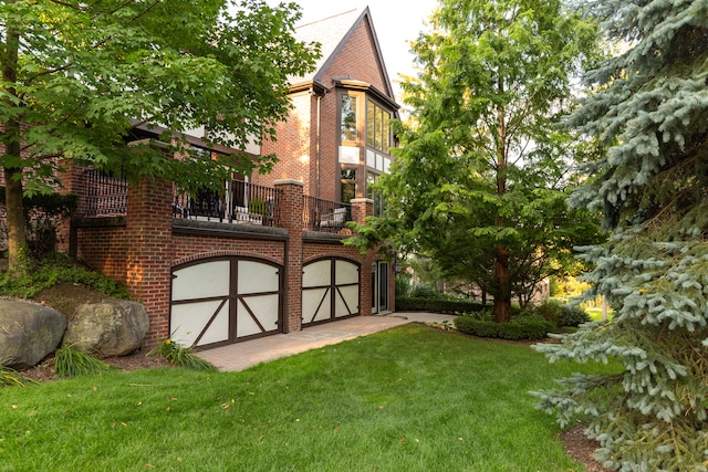 rear view of house featuring a garage and a lawn