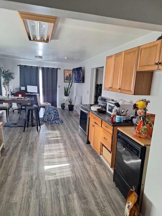 kitchen featuring stainless steel range with electric cooktop, dishwasher, and hardwood / wood-style flooring