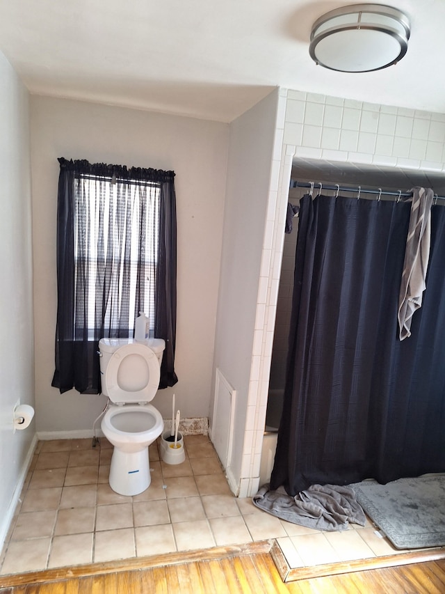 bathroom with toilet, shower / bath combination with curtain, and tile patterned flooring