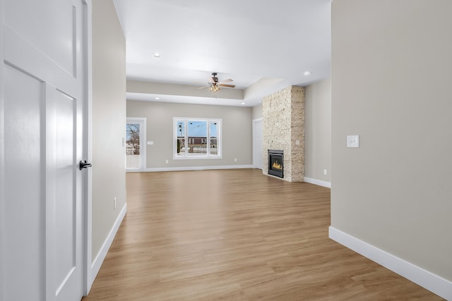 unfurnished living room with light hardwood / wood-style floors, ceiling fan, and a fireplace