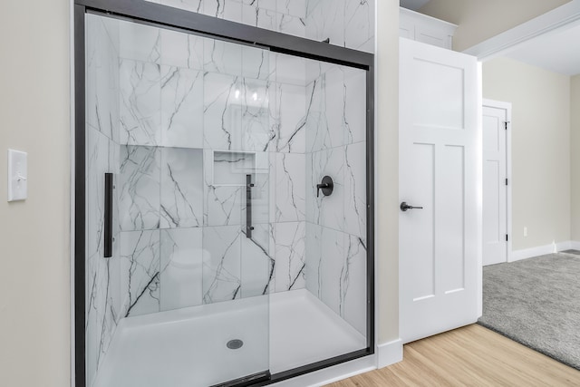 bathroom with an enclosed shower and wood-type flooring