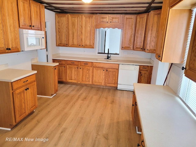 kitchen featuring sink, white appliances, and light hardwood / wood-style flooring