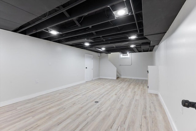 basement with light hardwood / wood-style flooring