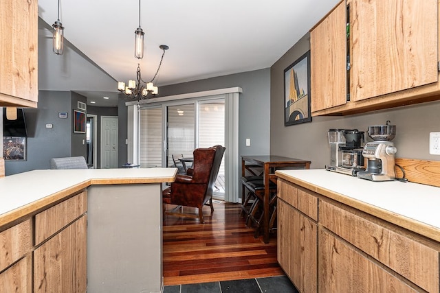 kitchen with a chandelier, light countertops, hanging light fixtures, and dark wood finished floors