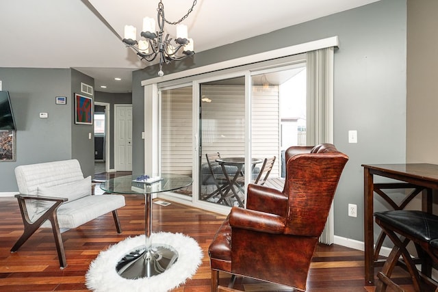 living area featuring an inviting chandelier, baseboards, visible vents, and dark wood-style flooring