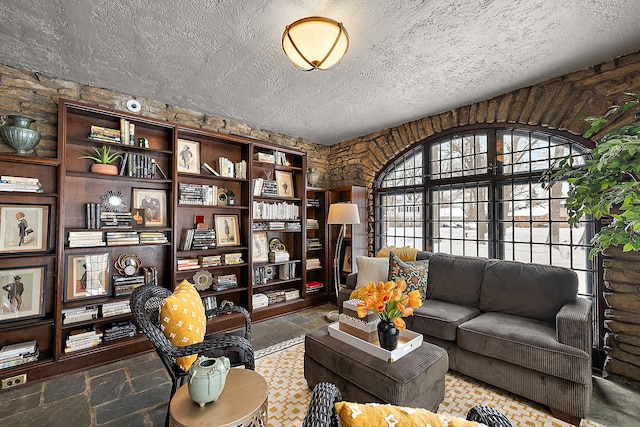 living room with a textured ceiling and stone tile floors