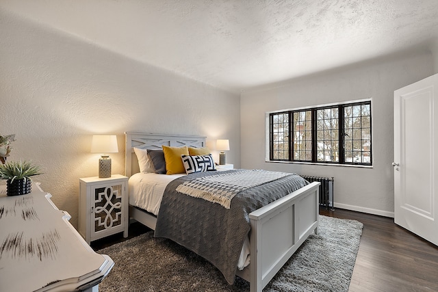 bedroom featuring dark wood finished floors, a textured wall, radiator heating unit, a textured ceiling, and baseboards