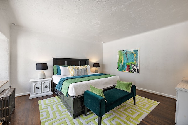 bedroom featuring radiator heating unit, a textured ceiling, baseboards, and dark wood-style flooring