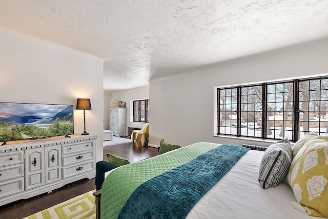 bedroom with a textured ceiling and dark wood-type flooring