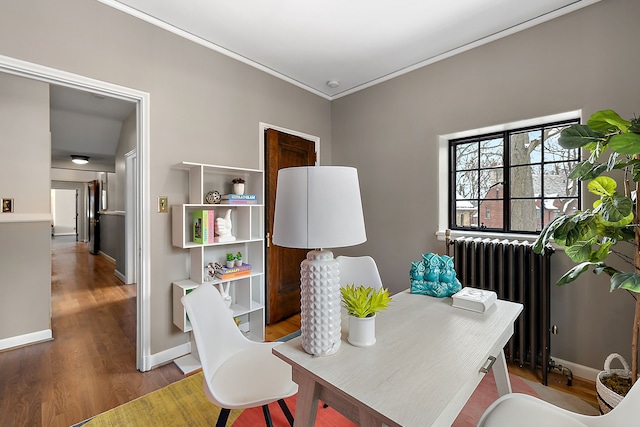 office area featuring radiator, baseboards, ornamental molding, and wood finished floors