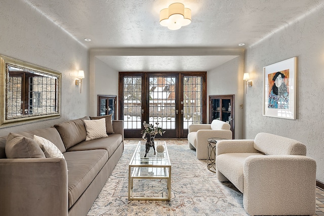 living area with a textured ceiling, a textured wall, and french doors