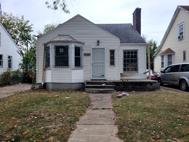 bungalow-style home with a front yard