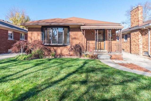 bungalow-style home with a front lawn and brick siding