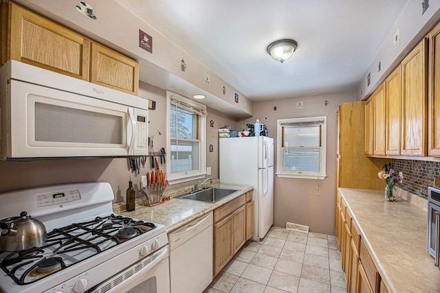 kitchen with white appliances, a wealth of natural light, sink, and decorative backsplash