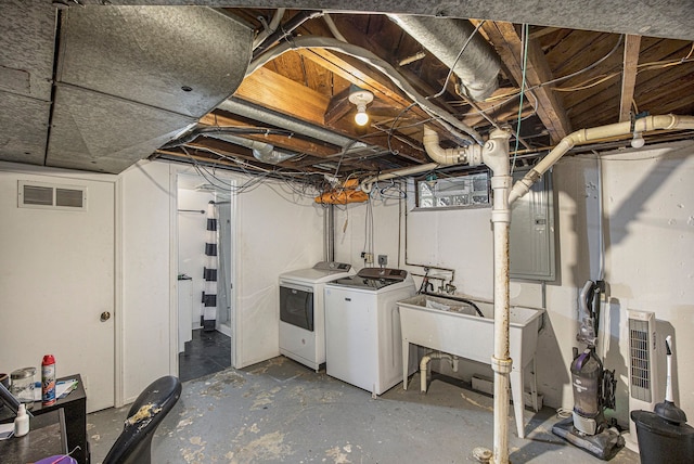 basement featuring electric panel, sink, and independent washer and dryer