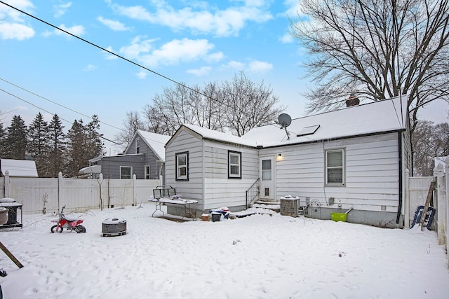 snow covered back of property featuring an outdoor fire pit