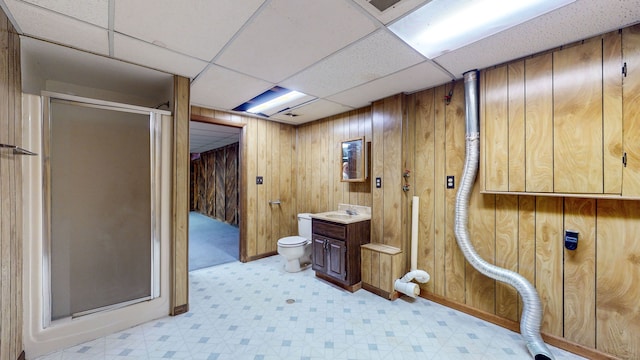 bathroom featuring toilet, wood walls, vanity, and walk in shower