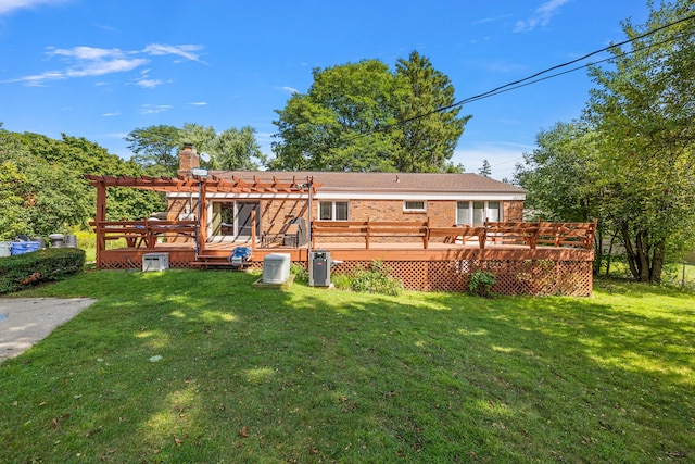 rear view of house with a chimney, a deck, a yard, a pergola, and brick siding