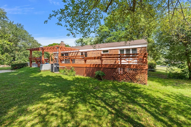 rear view of house with brick siding, fence, a deck, and a yard