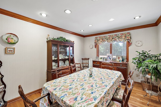 dining room with ornamental molding, baseboards, and light wood finished floors