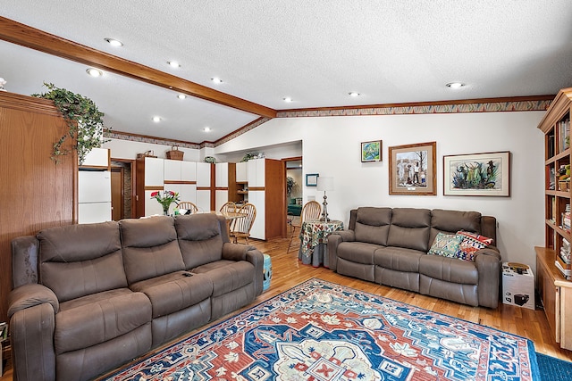 living room with vaulted ceiling with beams, a textured ceiling, and light wood-type flooring