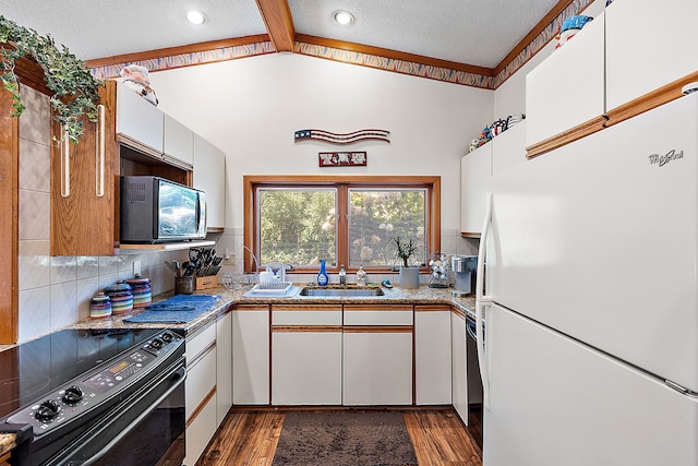 kitchen with black appliances, tasteful backsplash, a sink, and wood finished floors