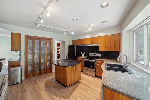 kitchen with a kitchen island, light hardwood / wood-style floors, sink, stainless steel electric range oven, and black fridge