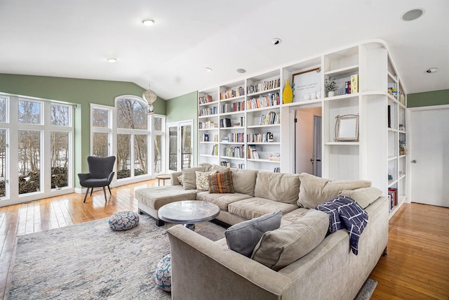 living room with light wood-type flooring and vaulted ceiling