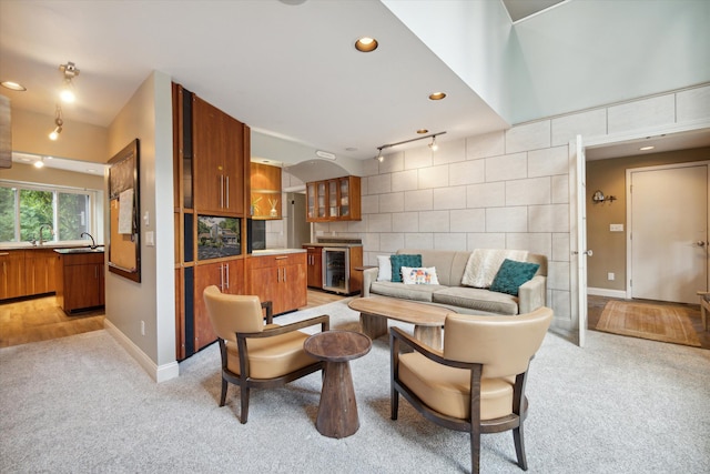 carpeted living room with sink and beverage cooler