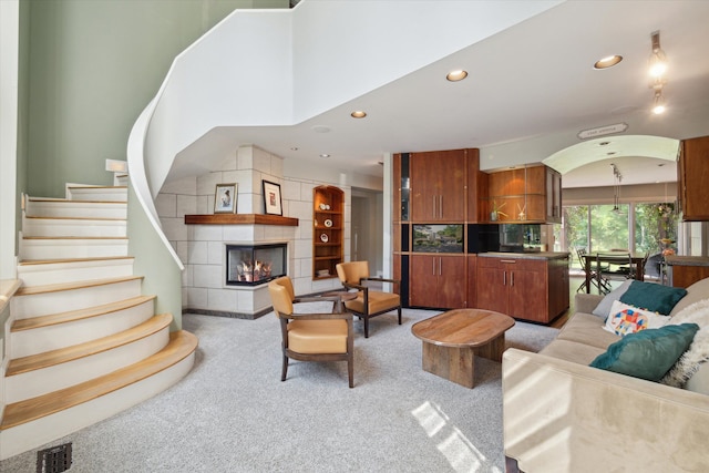 carpeted living room featuring a tile fireplace