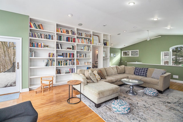 living room featuring hardwood / wood-style flooring, ceiling fan, vaulted ceiling, and built in features