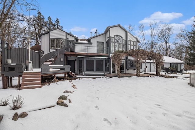 snow covered house featuring a balcony