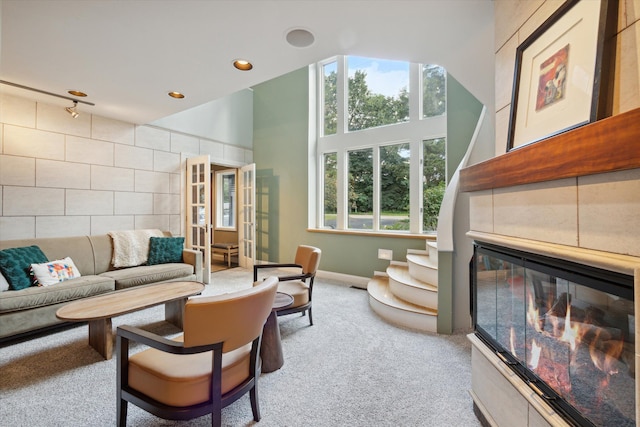 living room featuring a towering ceiling and light colored carpet