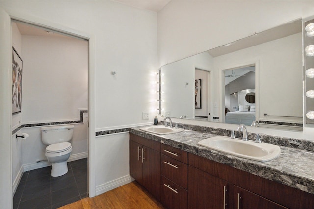 bathroom with hardwood / wood-style flooring, vanity, and toilet