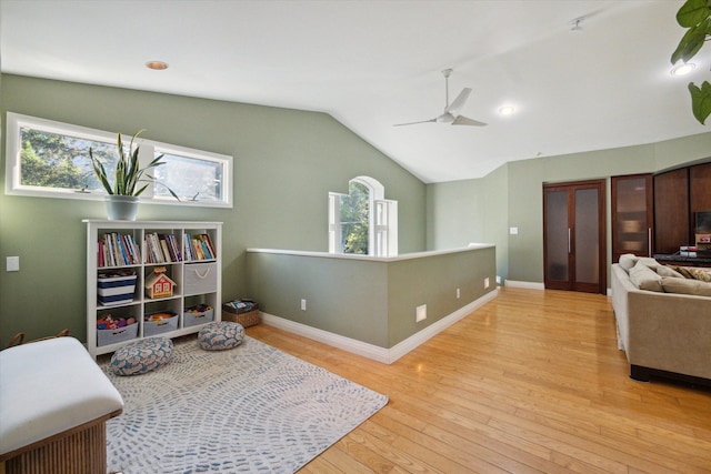 interior space with ceiling fan, lofted ceiling, plenty of natural light, and light hardwood / wood-style flooring