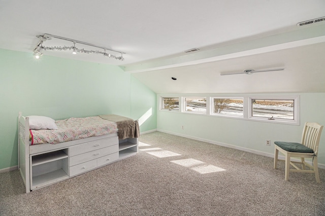 carpeted bedroom with lofted ceiling with beams and track lighting