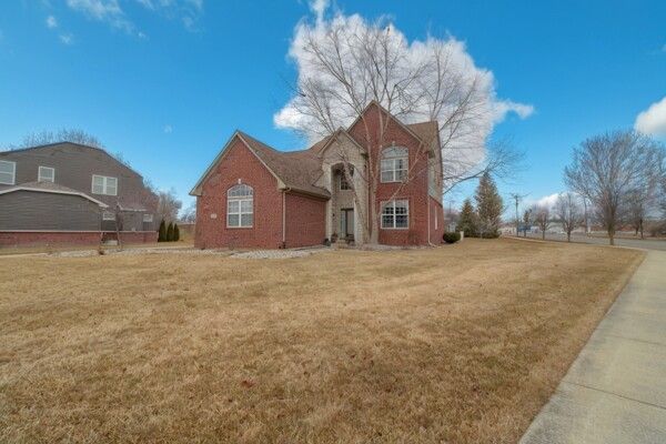 view of front facade with a front lawn and brick siding