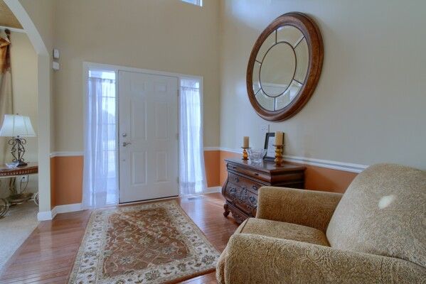 entryway with a high ceiling, a wealth of natural light, and wood finished floors