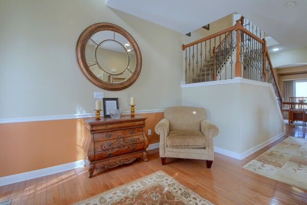 living area with stairs, wood finished floors, and baseboards