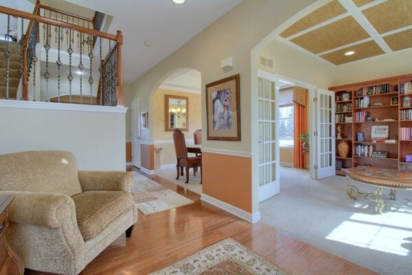 sitting room with arched walkways, wood finished floors, visible vents, baseboards, and french doors