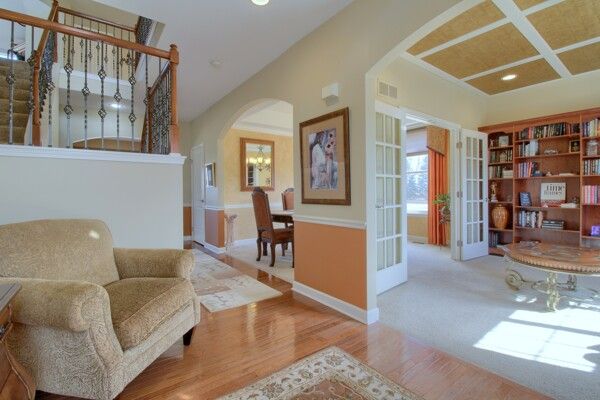 9077 Chambord Dr, Ypsilanti, MI 48197 - living area with arched walkways, visible vents, stairway, and wood finished floors
