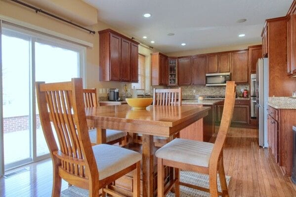 kitchen featuring stainless steel appliances, light wood-type flooring, a wealth of natural light, and brown cabinets