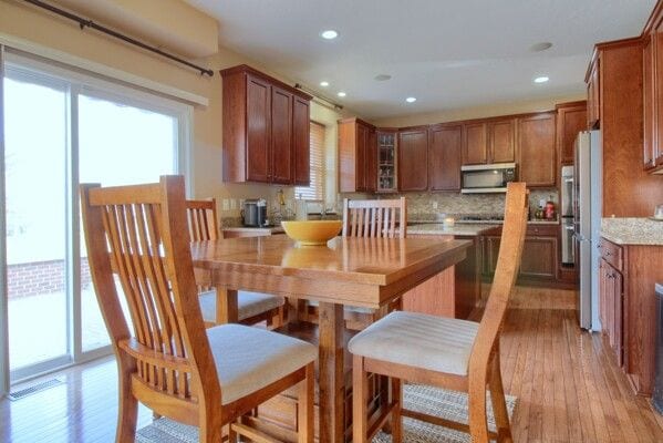 9077 Chambord Dr, Ypsilanti, MI 48197 - kitchen featuring brown cabinetry, a healthy amount of sunlight, stainless steel appliances, and light wood-style flooring