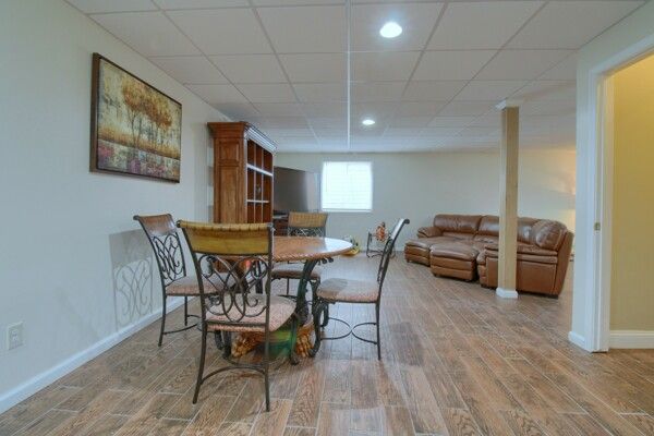 dining space featuring light wood-type flooring, baseboards, a drop ceiling, and recessed lighting