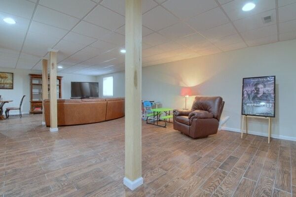 9077 Chambord Dr, Ypsilanti, MI 48197 - interior space featuring wood finished floors, visible vents, a drop ceiling, and baseboards