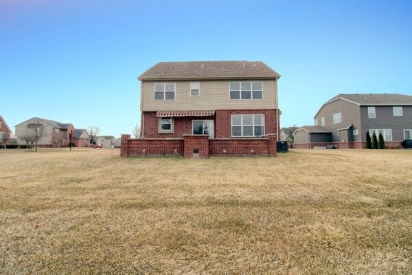 9077 Chambord Dr, Ypsilanti, MI 48197 - back of property with a lawn and brick siding