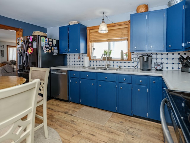 kitchen with sink, range, blue cabinets, and dishwasher