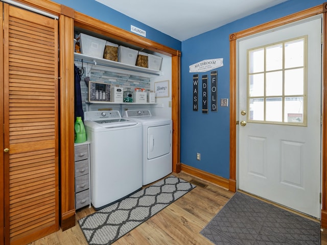 laundry area featuring washer and dryer and light hardwood / wood-style floors